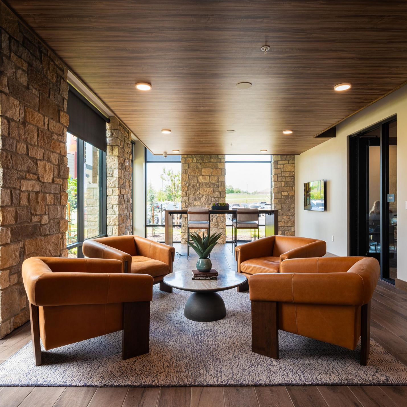 Wheatfield Village resident clubroom with modern plush armchairs circled around a coffee table in a sleek room.