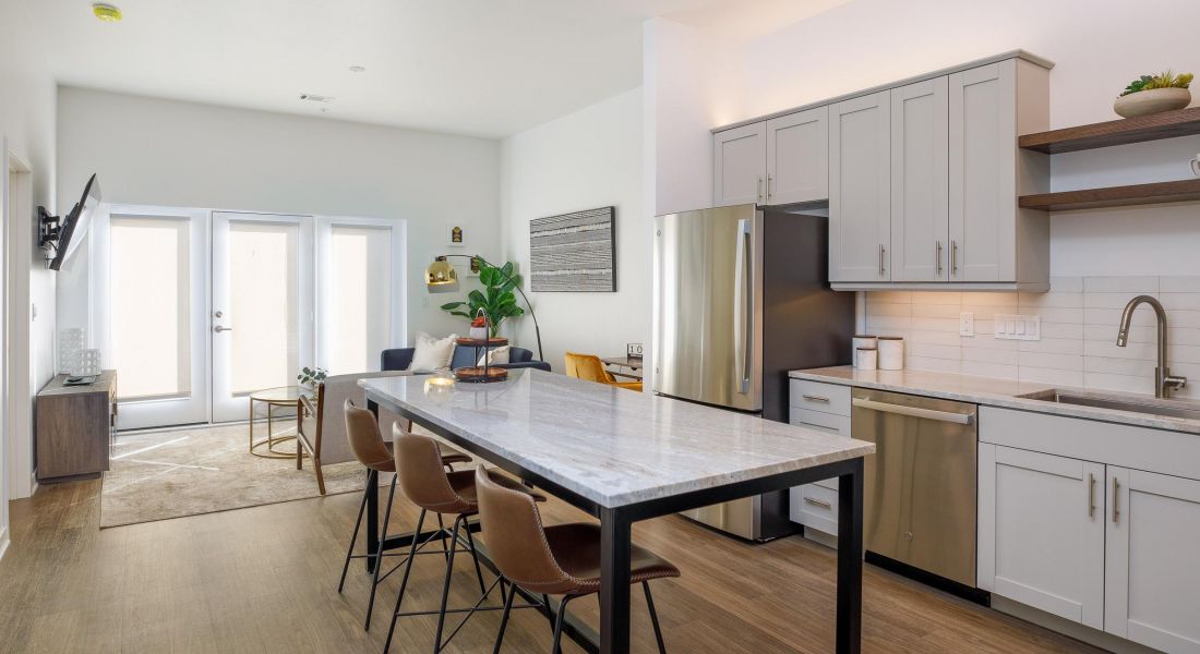 Bright and airy kitchen and dining space at Wheatfield Village featuring sleek appliances.