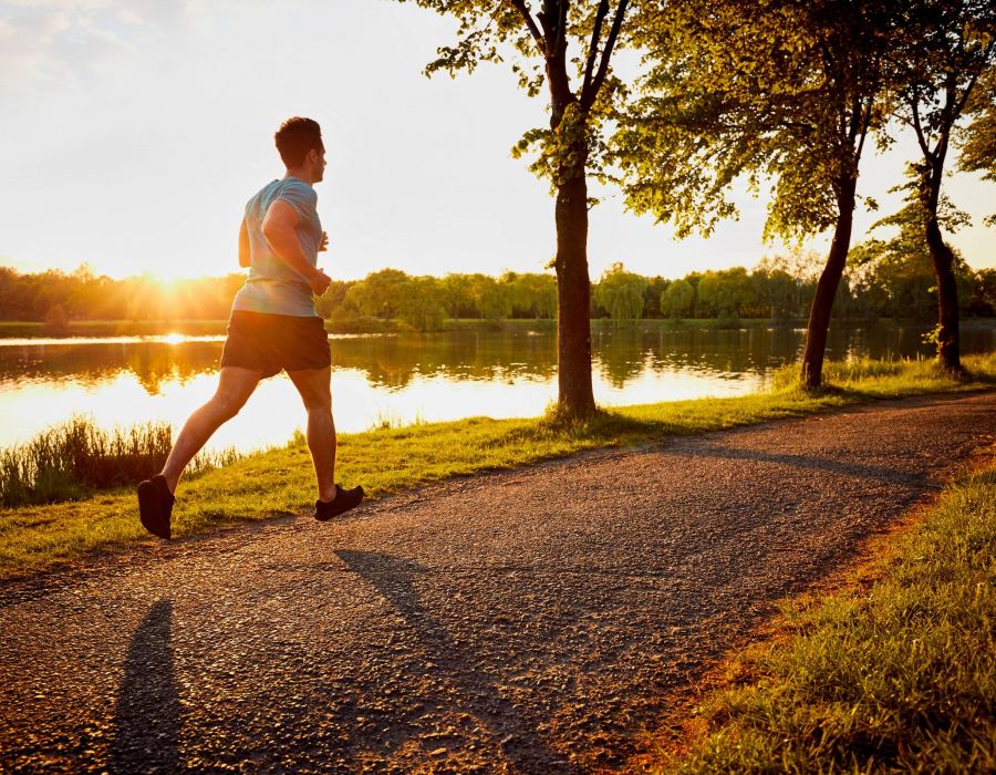 Young man jogging in park during sunset near Wheatfield Village apartments