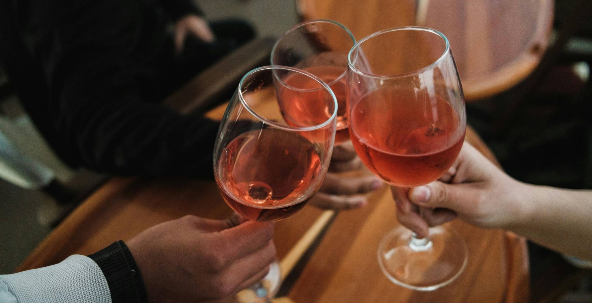Friends clinking wine glasses at a restaurant neat Wheatfield Village apartments.