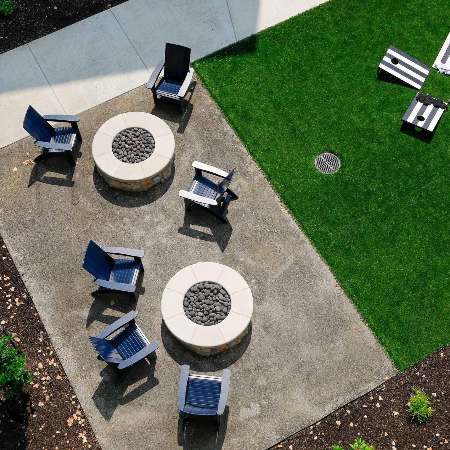 Wheatfield Village apartments aerial view of outdoor fire pit area with corn hole games.