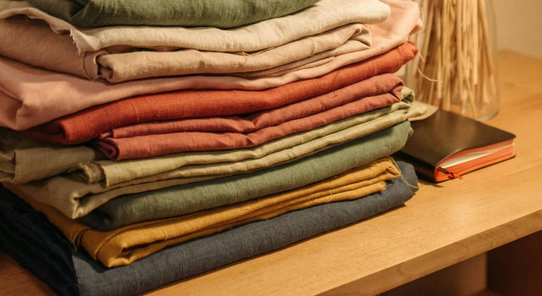 Neatly folded clothes stacked on a table with decorative elements at Wheatfield Village.