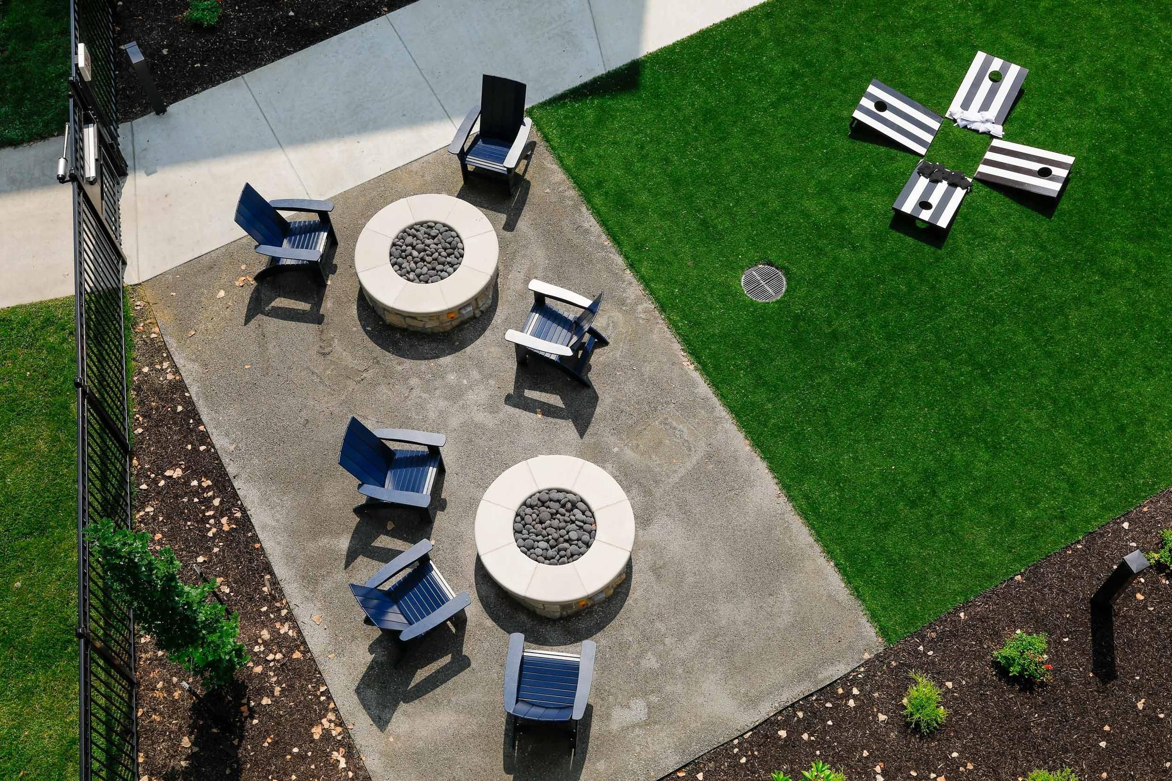 Wheatfield Village apartments aerial view of outdoor fire pit area with corn hole games.